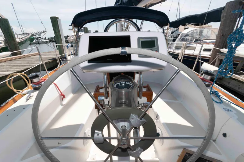 Slide: The Image of Steering wheel of a 1994 Tartan 31 sailboat docked at a marina. - 4