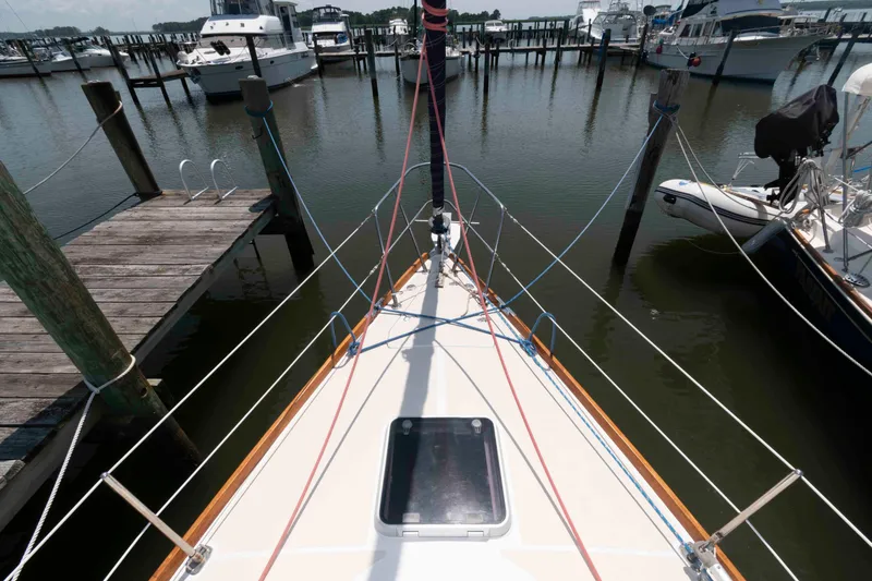 Slide: The Image of Bow view of a 1994 Tartan 31 sailboat docked at a marina. - 7