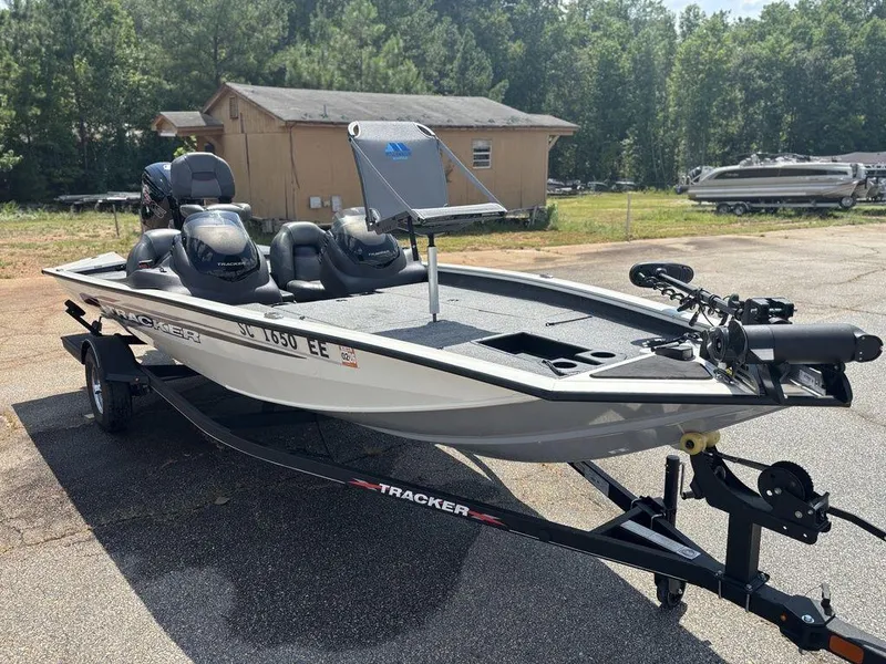 Slide: The Image of 2013 Tracker Pro Team™ 190 TX boat on trailer, parked outdoors near trees and a building. - 10