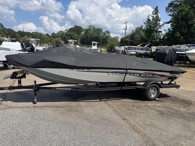 Slide: The Image of 2013 Tracker Pro Team™ 190 TX boat covered on trailer, parked outdoors. - 14