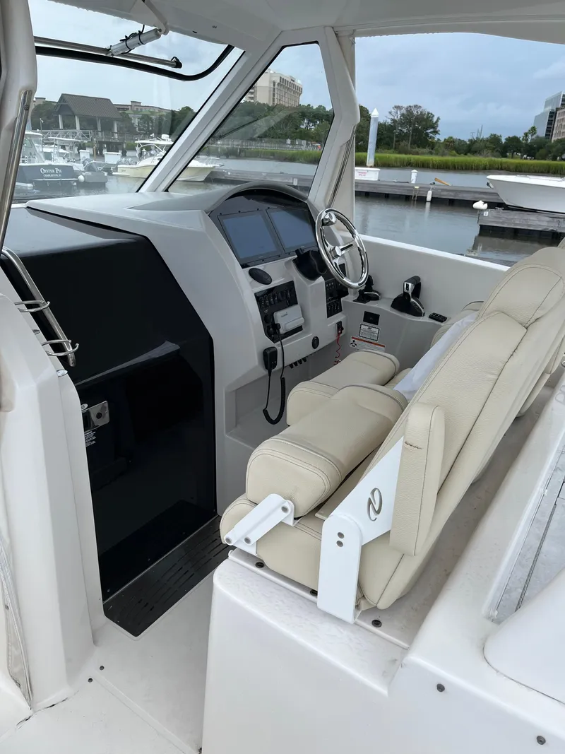 Slide: The Image of 2022 Regal 33 SAV boat cockpit with modern controls and beige seating. - 10