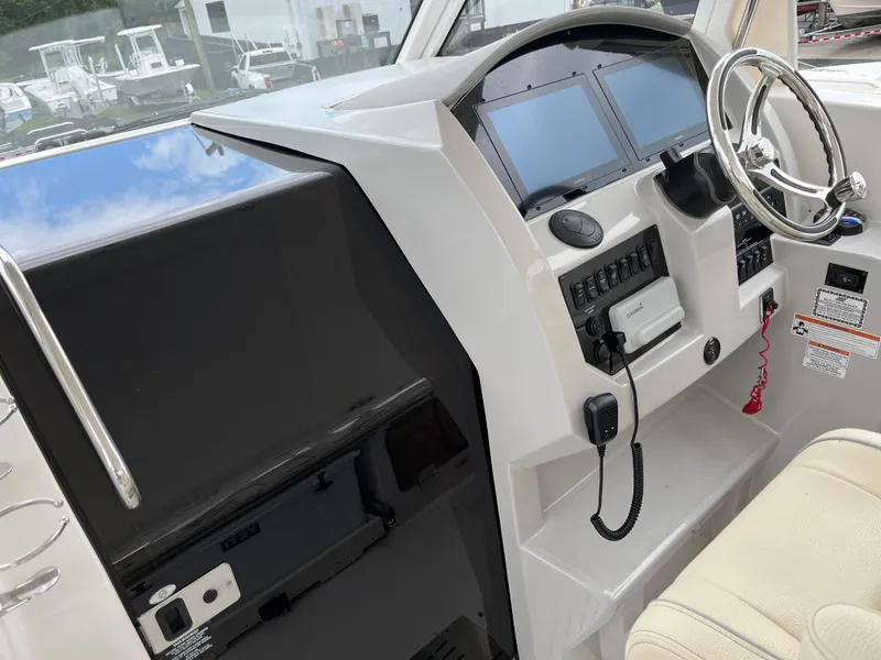 Slide: The Image of 2022 Regal 33 SAV boat dashboard with steering wheel and control panels. - 11