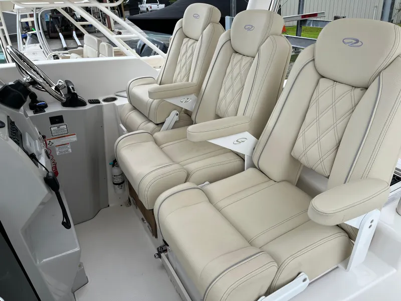 Slide: The Image of Luxurious seating on 2022 Regal 33 SAV boat, featuring plush, cream-colored upholstery. - 12