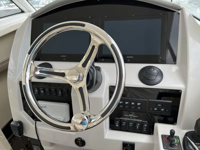 Slide: The Image of 2022 Regal 33 SAV helm with dual Garmin displays and modern controls. - 13