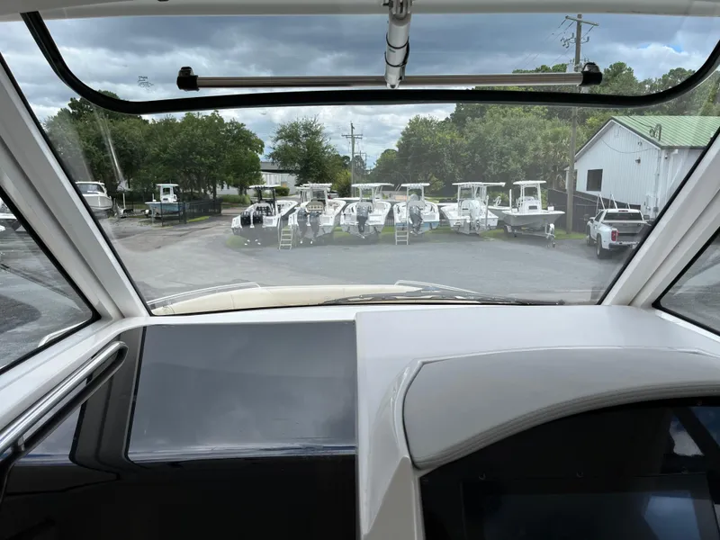 Slide: The Image of View from 2022 Regal 33 SAV boat cockpit, overlooking parked boats and cloudy sky. - 15