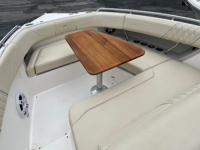 Slide: The Image of 2022 Regal 33 SAV boat interior with cushioned seating and wooden table. - 19