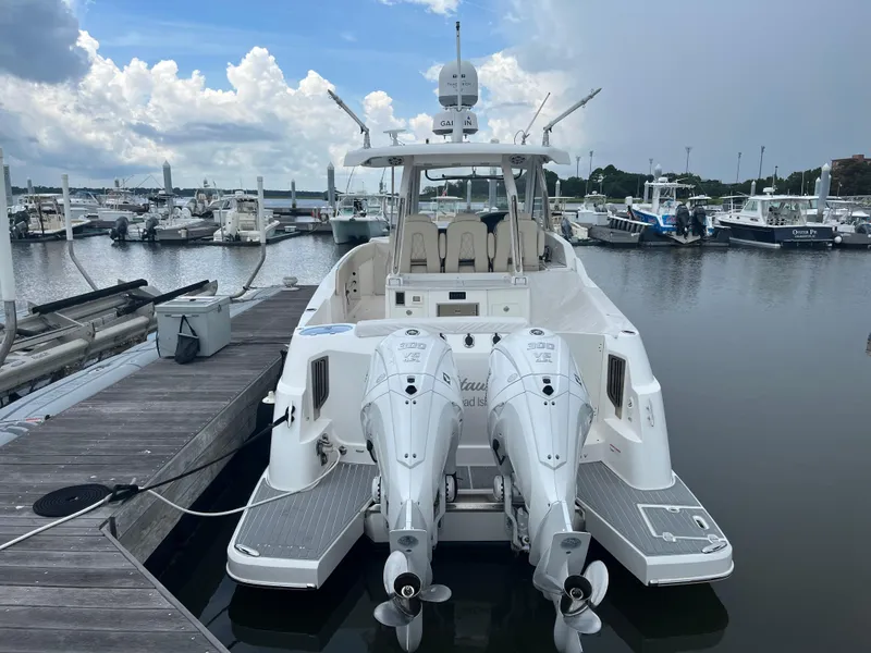 Slide: The Image of 2022 Regal 33 SAV boat docked at marina with twin outboard engines. - 2