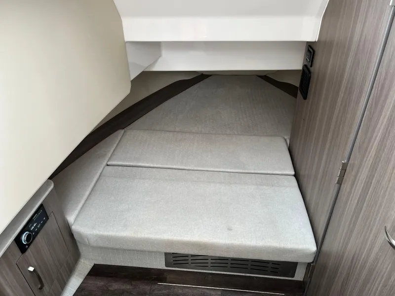 Slide: The Image of 2022 Regal 33 SAV cabin interior with cushioned seating and modern wood paneling. - 26