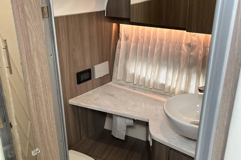 Slide: The Image of 2022 Regal 33 SAV bathroom with modern sink, wood paneling, and ambient lighting. - 29