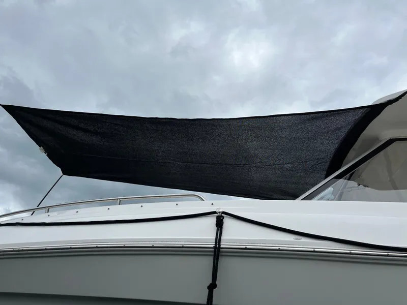 Slide: The Image of 2022 Regal 33 SAV boat with black sunshade under cloudy sky. - 31