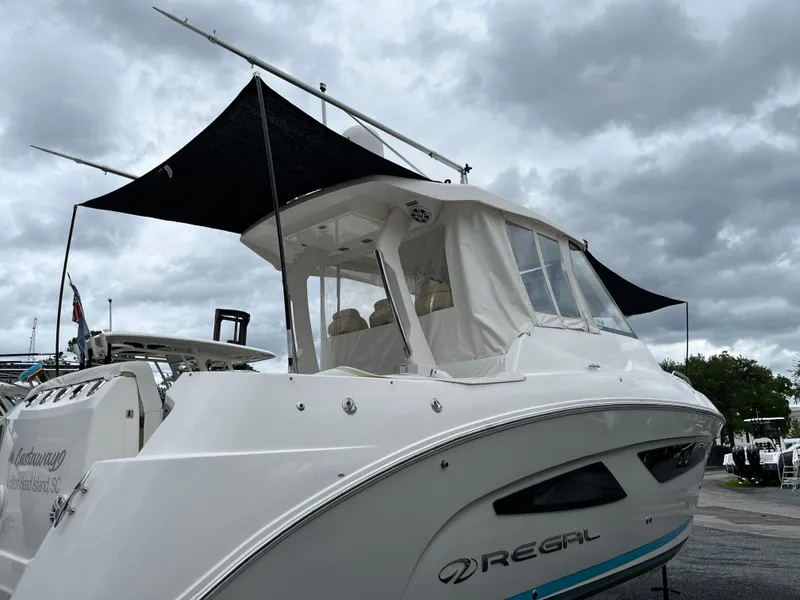 Slide: The Image of 2022 Regal 33 SAV boat with canopy under cloudy sky. - 34