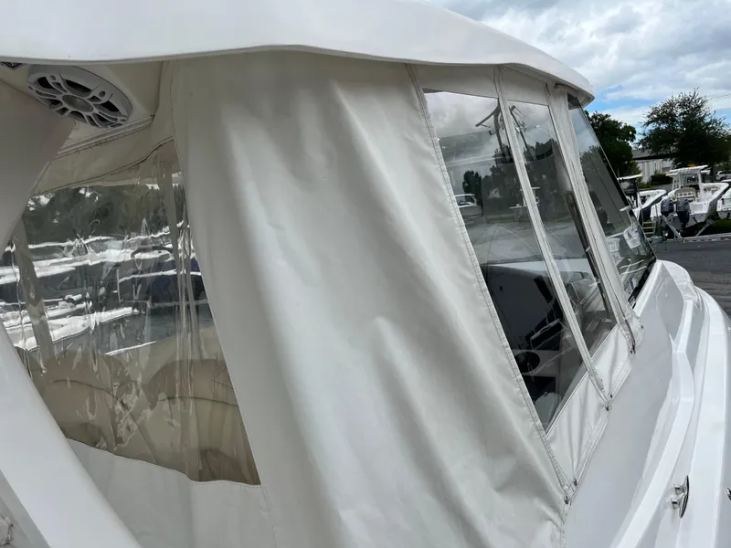 Slide: The Image of 2022 Regal 33 SAV boat with white canopy and clear windows, docked outdoors. - 36
