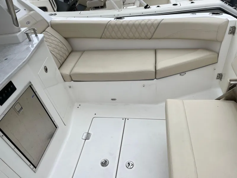 Slide: The Image of 2022 Regal 33 SAV boat interior with beige seating and storage compartments. - 4