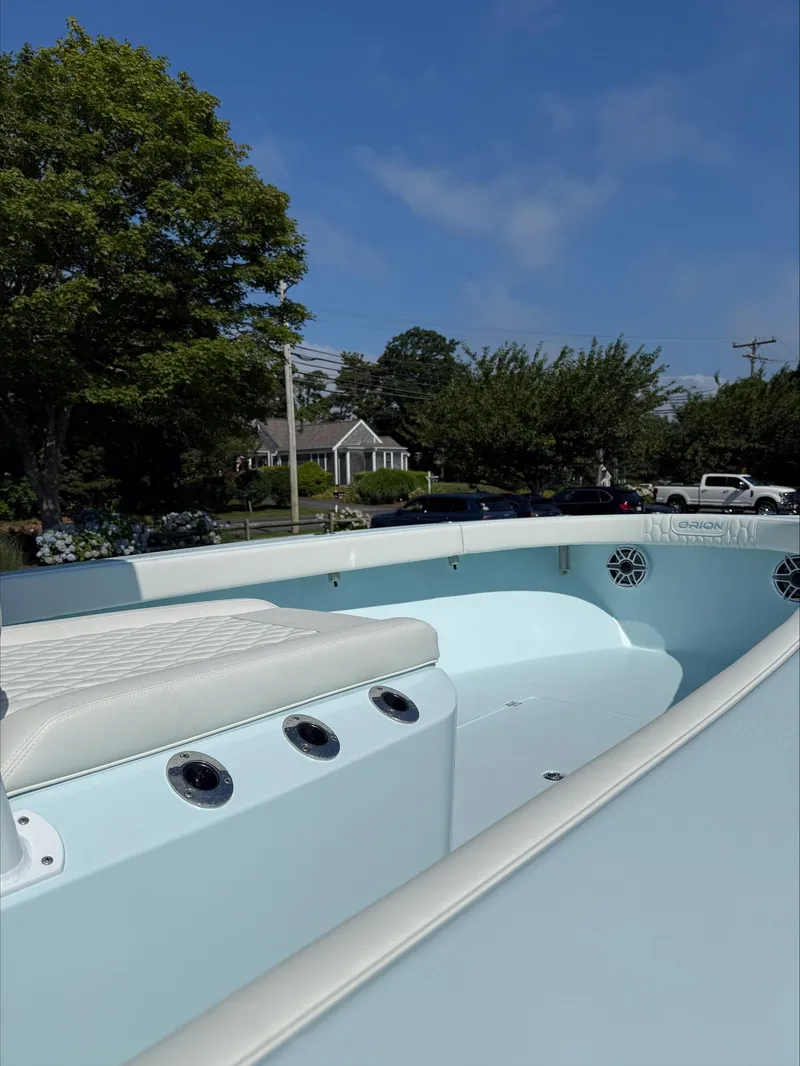 Slide: The Image of 2025 Orion 29 CC boat interior with white seating, set against a suburban backdrop. - 5
