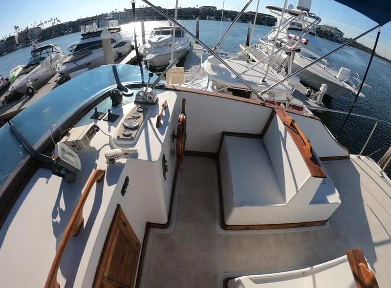 Slide: The Image of 1977 CHB 34 yacht interior with helm, seating, and marina view. - 11
