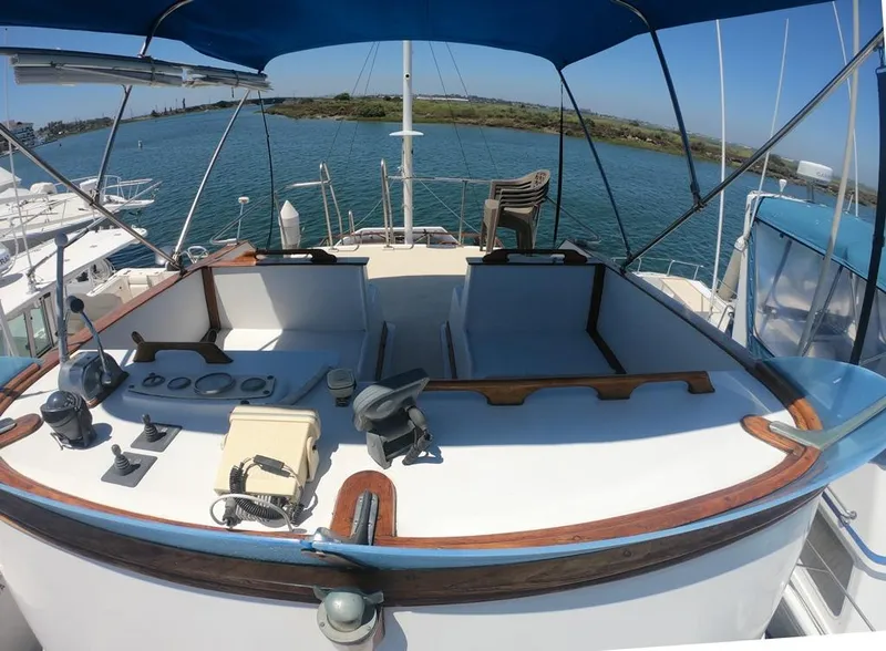 Slide: The Image of 1977 CHB 34 boat deck with blue canopy, docked by the water. - 13