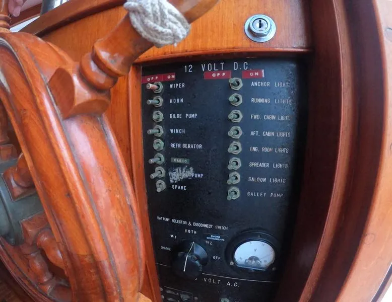 Slide: The Image of 1977 CHB 34 boat control panel with wooden steering wheel and 12-volt DC switches. - 18