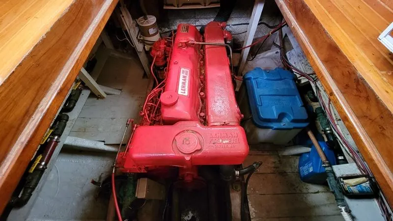 Slide: The Image of 1977 CHB 34 boat engine compartment with red engine and blue battery. - 22