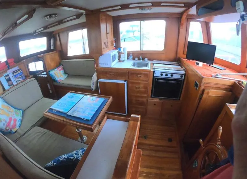 Slide: The Image of Interior of a 1977 CHB 34 boat with kitchen, seating area, and navigation station. - 26