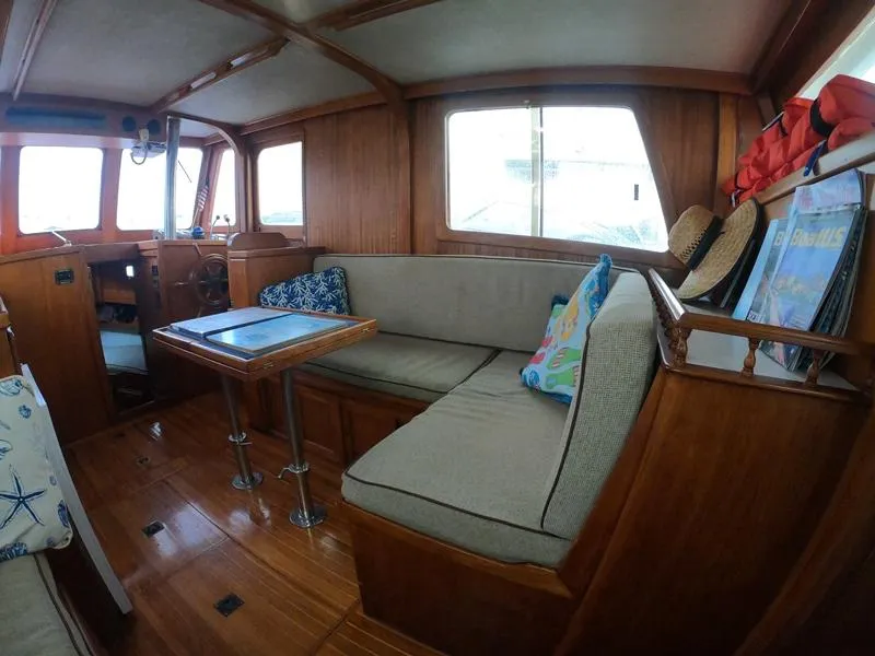 Slide: The Image of 1977 CHB 34 boat interior with wooden finish, cozy seating, and nautical decor. - 29