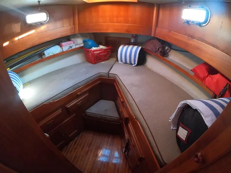 Slide: The Image of Cozy cabin interior of a 1977 CHB 34 boat with wooden finishes and storage. - 35