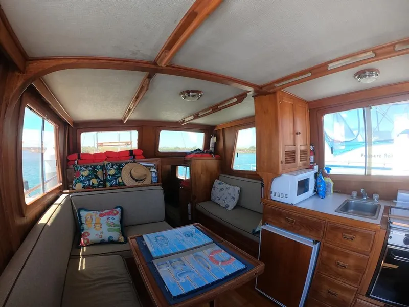 Slide: The Image of Interior of 1977 CHB 34 boat with cozy seating, table, and kitchenette. - 37