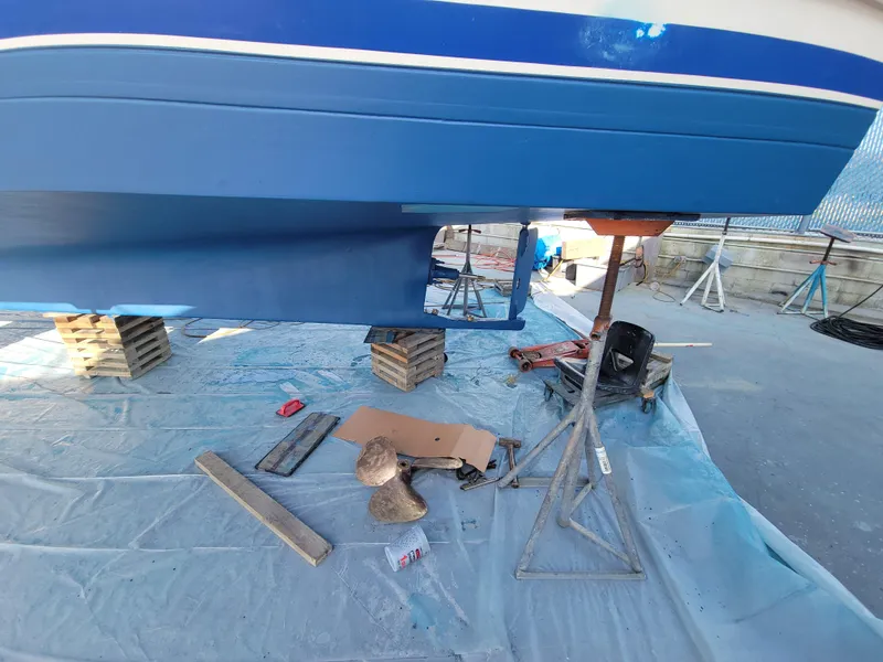 Slide: The Image of 1977 CHB 34 boat hull on stands, undergoing maintenance in a shipyard. - 44