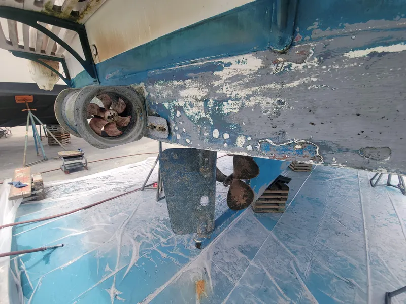 Slide: The Image of 1977 CHB 34 boat hull with visible wear and propeller in dry dock. - 45