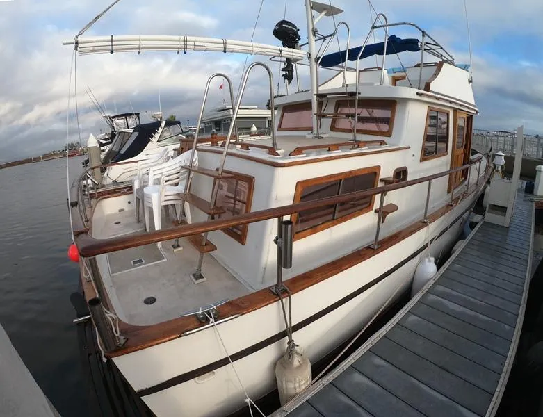Slide: The Image of 1977 CHB 34 yacht docked at marina with wooden trim and white chairs. - 5