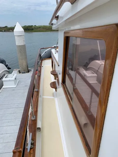 Slide: The Image of 1977 CHB 34 boat docked at a marina, showcasing wooden railings and windows. - 6