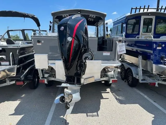 Slide: The Image of 2025 Spartan 220 Maximus Pro boat with powerful outboard motor, parked in a lot. - 4