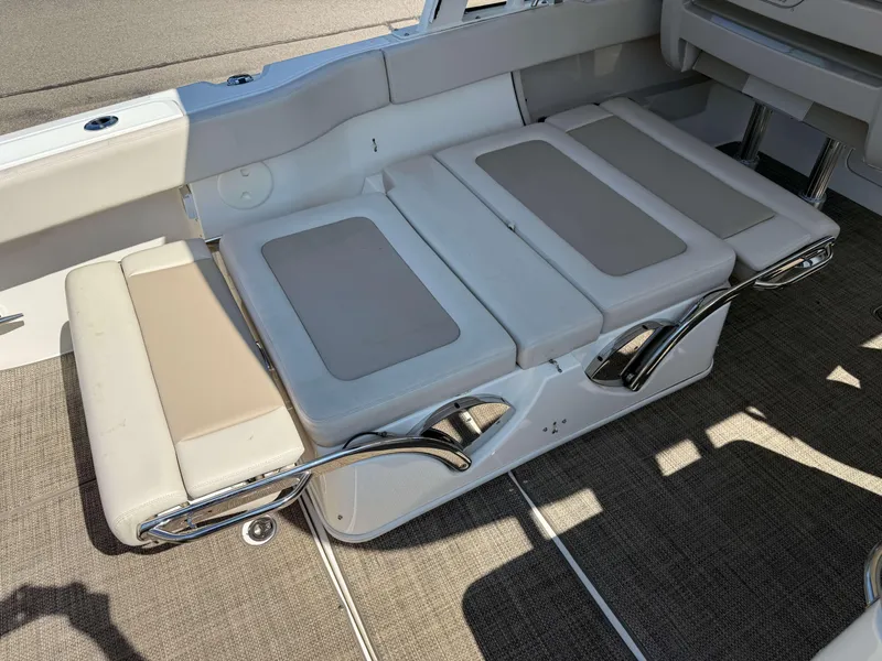 Slide: The Image of 2017 Boston Whaler 320 Vantage boat interior seating with beige cushions and chrome accents. - 10