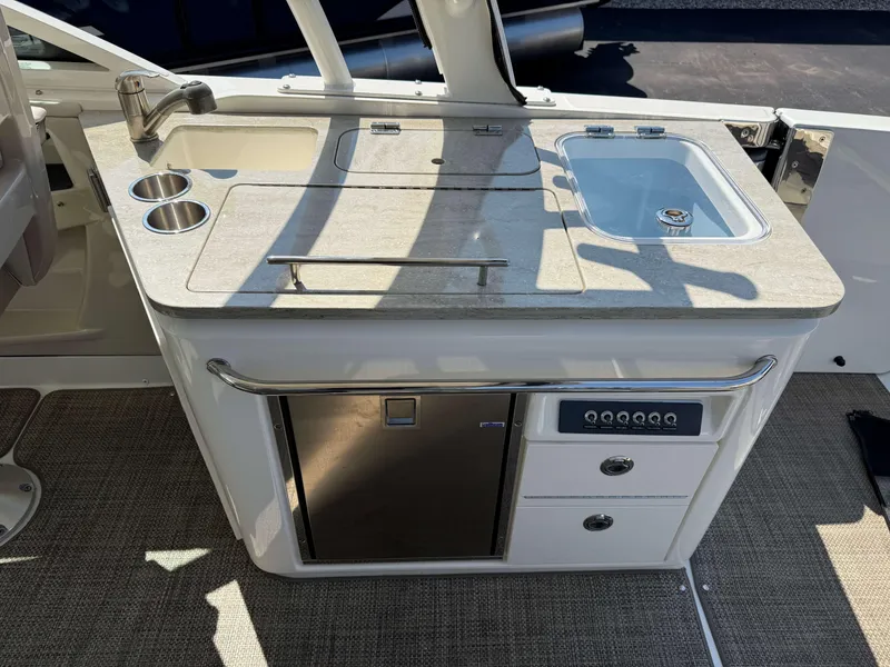 Slide: The Image of Boston Whaler 320 Vantage 2017 boat kitchenette with sink, storage, and countertop. - 12