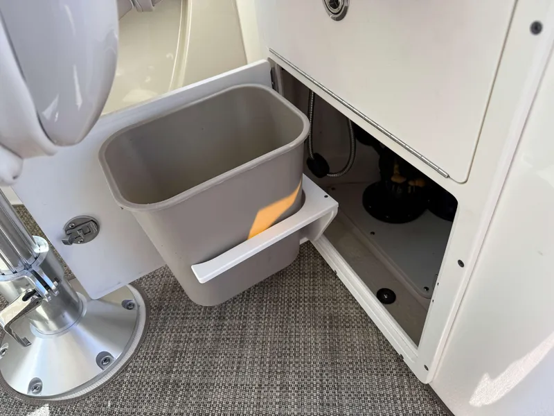 Slide: The Image of 2017 Boston Whaler 320 Vantage interior with storage compartment and trash bin. - 16