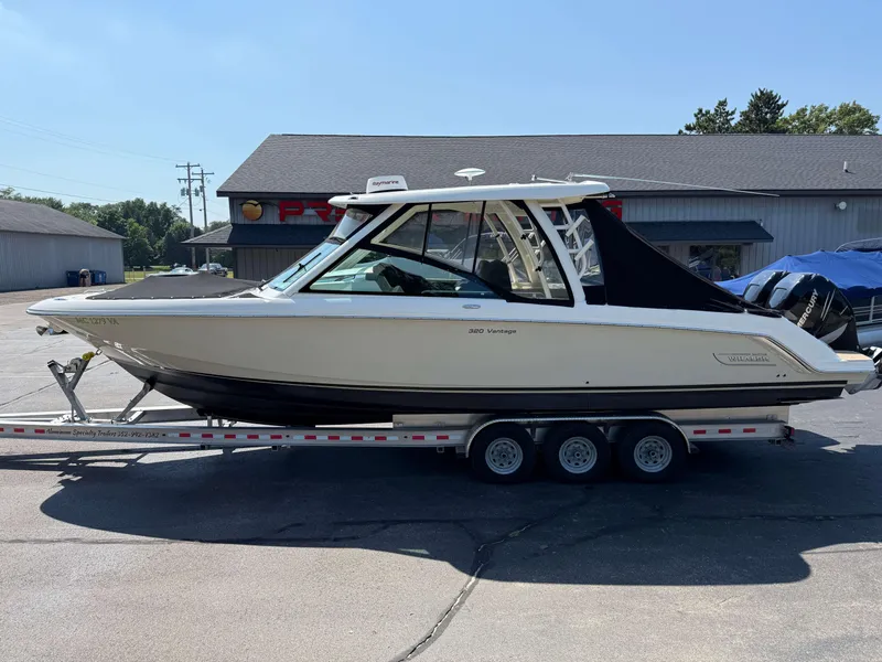 Slide: The Image of 2017 Boston Whaler 320 Vantage boat on a trailer, parked outdoors. - 2