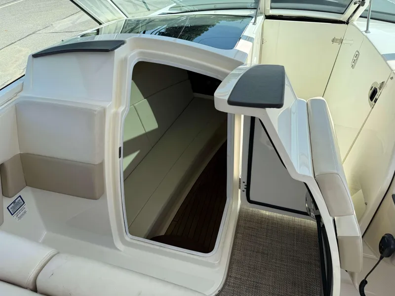 Slide: The Image of 2017 Boston Whaler 320 Vantage cabin entrance with seating and open door. - 20