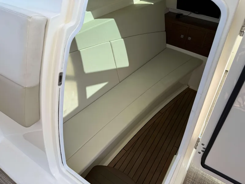 Slide: The Image of Interior view of 2017 Boston Whaler 320 Vantage with cushioned seating and wooden flooring. - 21
