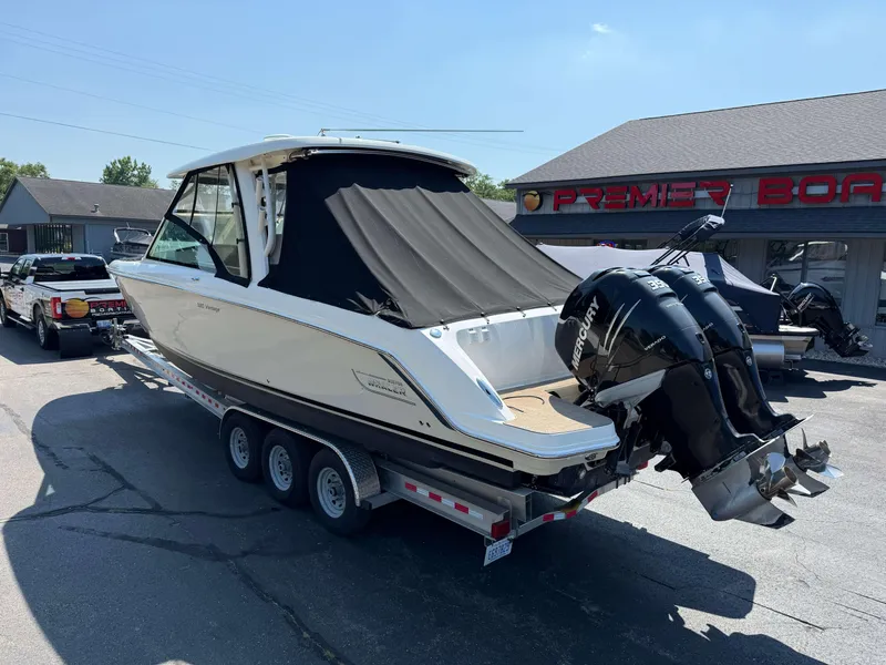 Slide: The Image of 2017 Boston Whaler 320 Vantage boat on trailer, twin Mercury engines, parked at dealership. - 3
