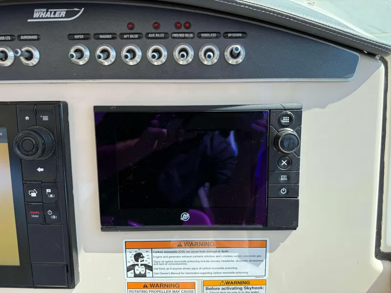 Slide: The Image of Control panel of a 2017 Boston Whaler 320 Vantage boat with warning labels. - 30
