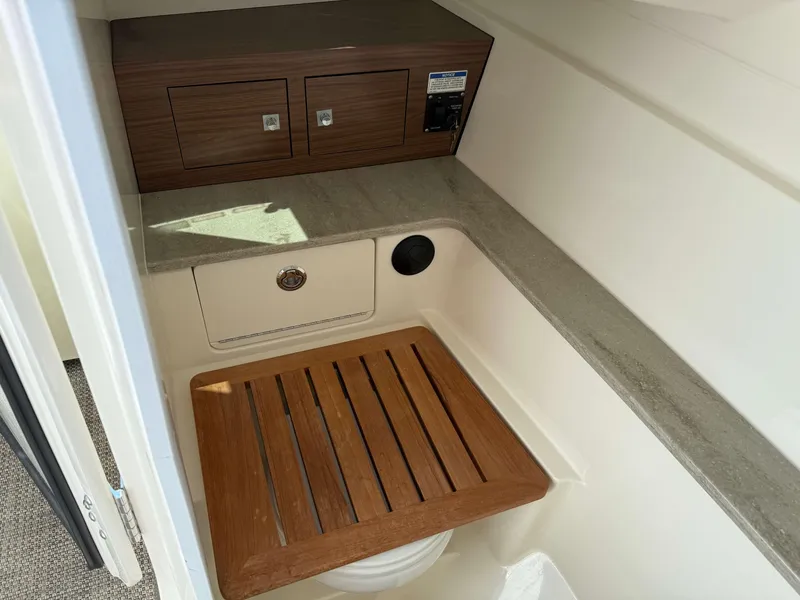 Slide: The Image of Interior of 2017 Boston Whaler 320 Vantage boat with wooden seat and storage. - 34