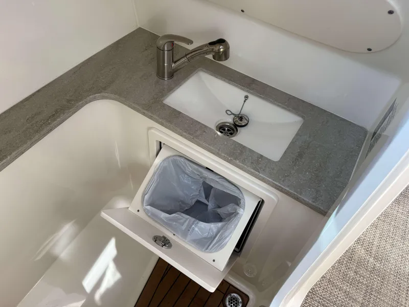 Slide: The Image of Interior of 2017 Boston Whaler 320 Vantage with sink and trash compartment. - 36