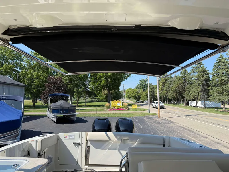 Slide: The Image of 2017 Boston Whaler 320 Vantage boat with canopy, parked near trees and road. - 45