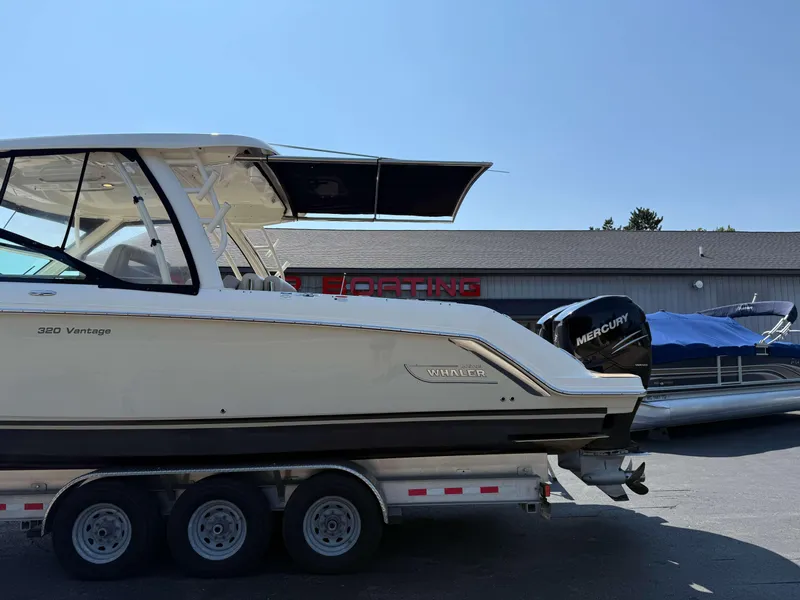 Slide: The Image of 2017 Boston Whaler 320 Vantage boat on trailer, parked outside a building. - 46