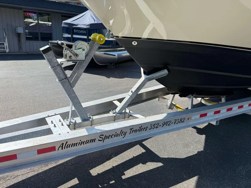 Slide: The Image of Trailer holding a 2017 Boston Whaler 320 Vantage boat, parked outside a building. - 49