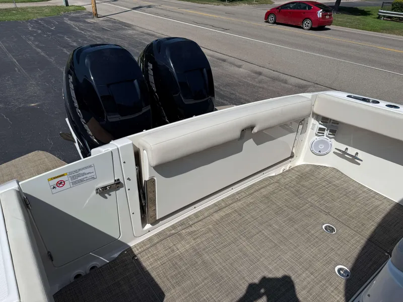 Slide: The Image of 2017 Boston Whaler 320 Vantage boat deck with twin Mercury engines, beige seating, and speaker. - 6