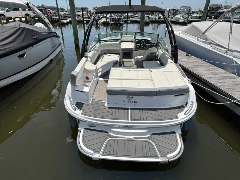 Slide: The Image of 2019 Cobalt 220S boat docked at marina, featuring spacious seating and sleek design. - 26