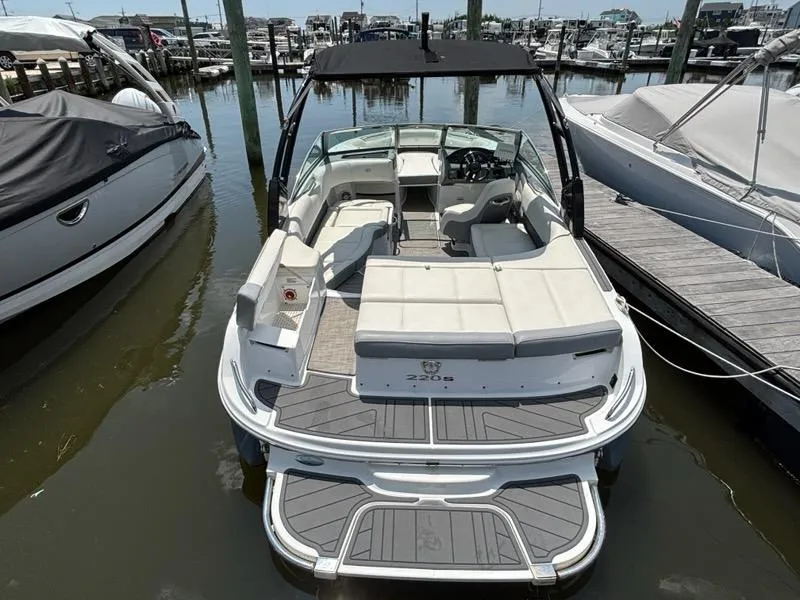 Slide: The Image of 2019 Cobalt 220S boat docked at marina, featuring spacious seating and sleek design. - 27