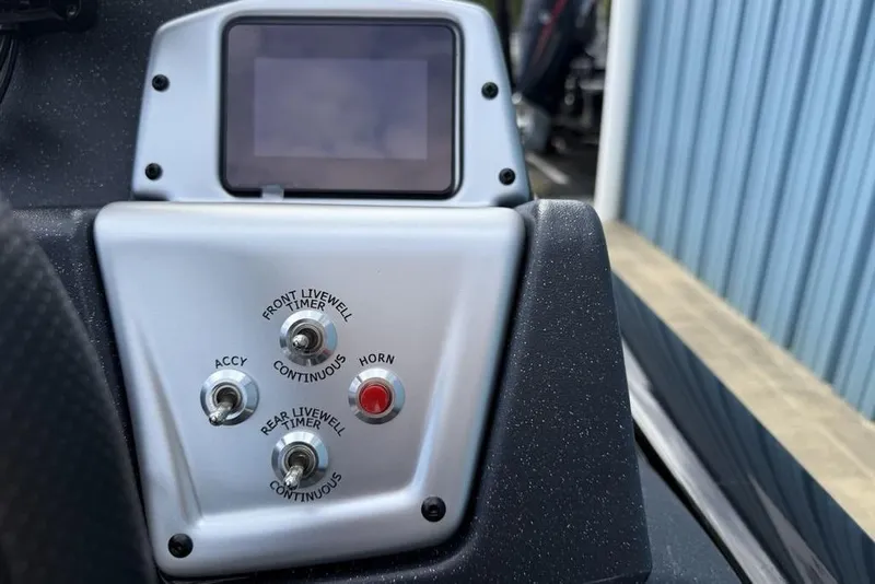 Slide: The Image of Control panel of 2026 Tracker Pro Team 175 Crappie Edition boat with switches and display. - 12