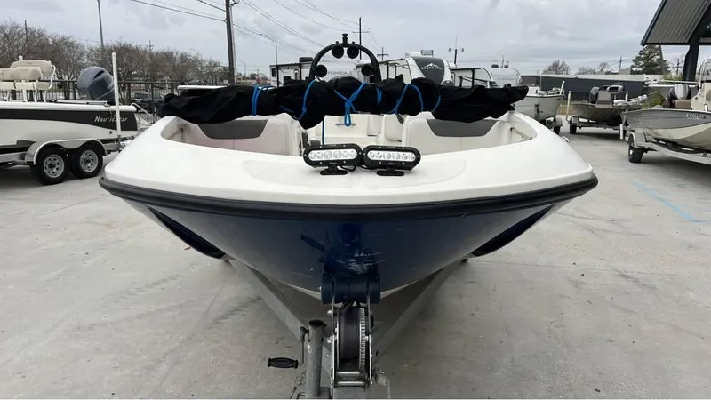 Slide: The Image of 2017 Bayliner Element F18 boat on trailer, front view, in a marina setting. - 2