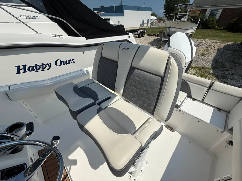 Slide: The Image of 2018 Tidewater 232 LXF boat interior with cushioned seating and steering wheel. - 10